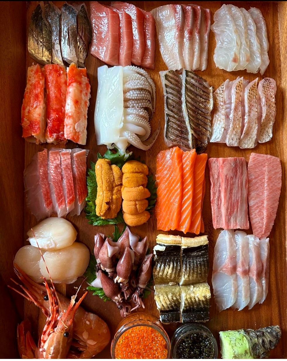 Sushi and sashimi combination platter — tuna, salmon, eel, snapper, shrimp, surimi, baby octopus, and California rolls
