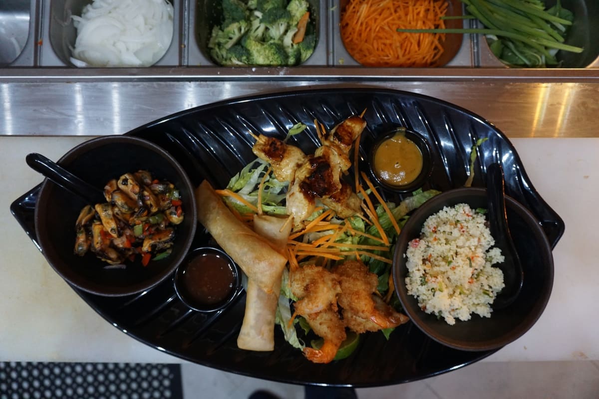 Aziana snack platter with chicken satay, shrimp, spring rolls and house sauces