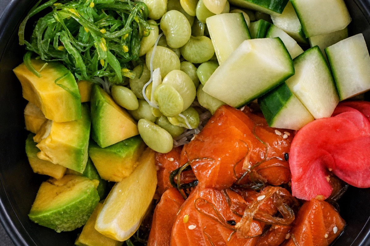 Salmon poke bowl with avocado, mango, edamame and cucumber