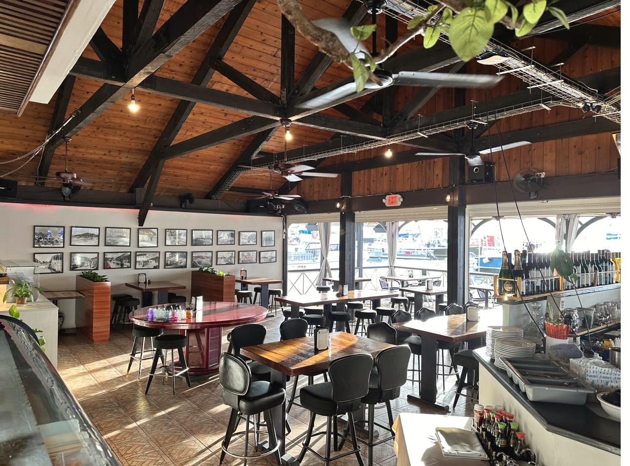 Aziana dining room with vaulted wood ceiling, historic photographs of old St. Maarten, and marina views